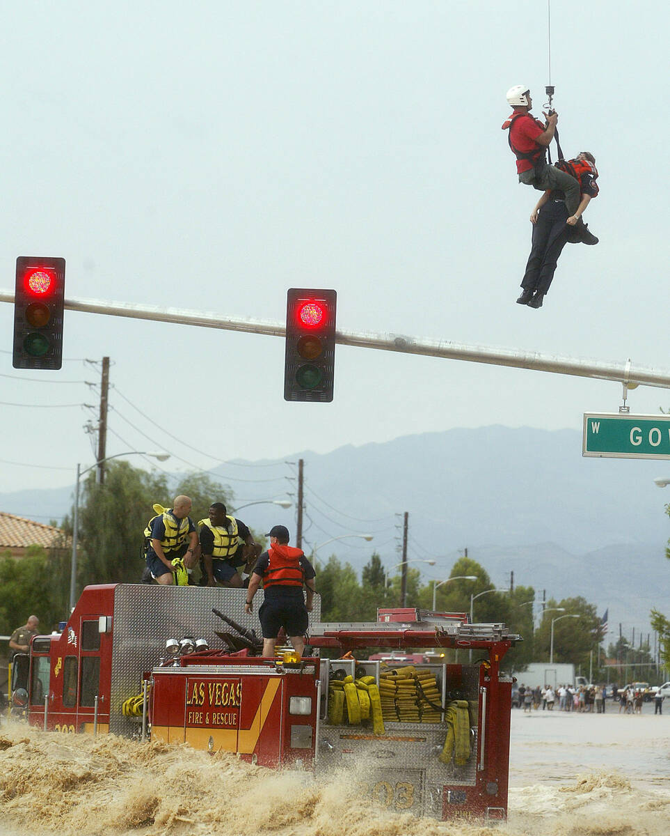 Members of the Las Vegas Fire and Rescue Department are rescued off a fire truck caught in floo ...
