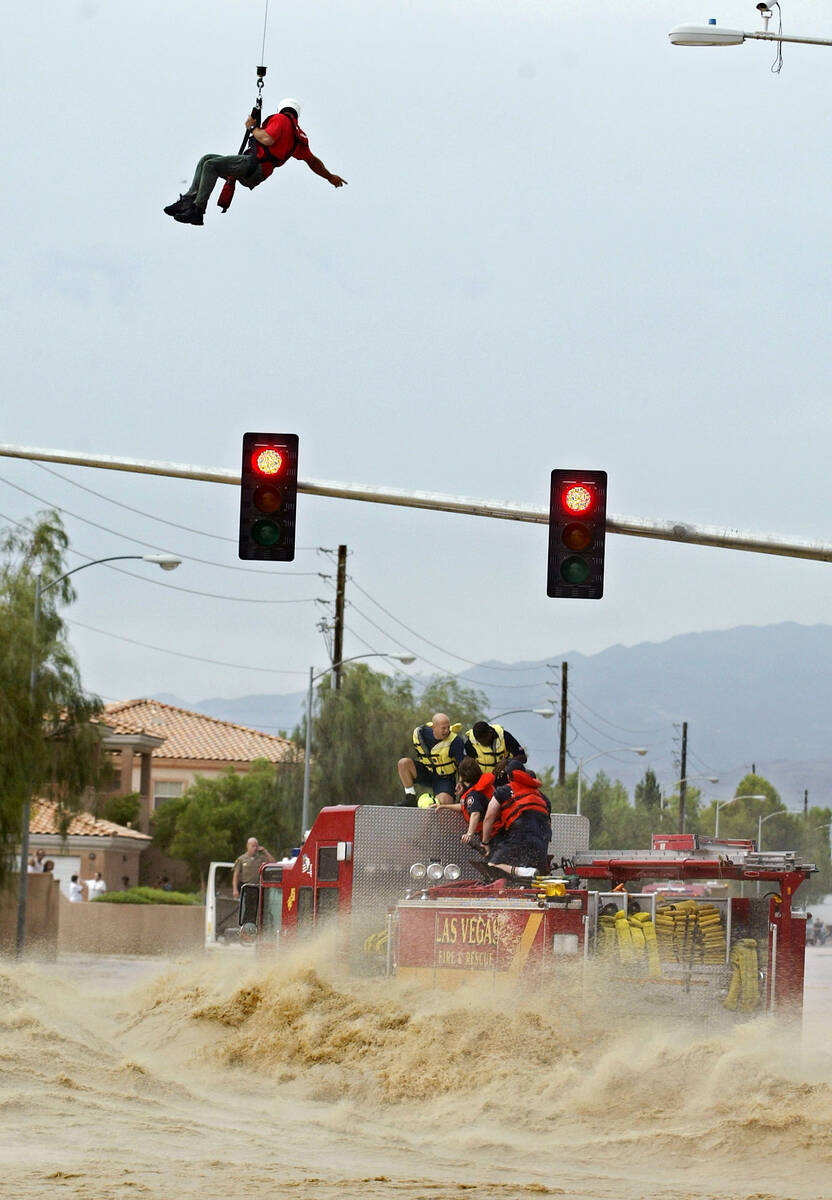 Las Vegas Fire & Rescue firefighters are rescued off of a fire truck caught in the torrent at t ...