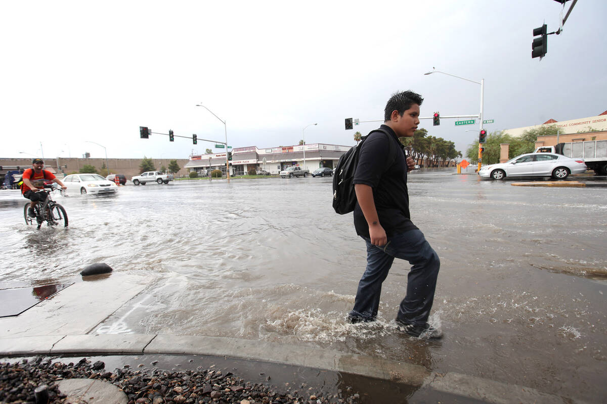 Fourteen-year-old Jonathan Gonzalez walks home from school through flooding along Eastern Avenu ...