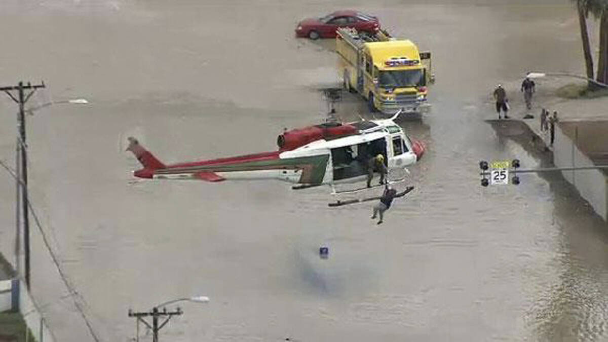 The Las Vegas police search and rescue team plucks a stranded motorist from a flooded road near ...