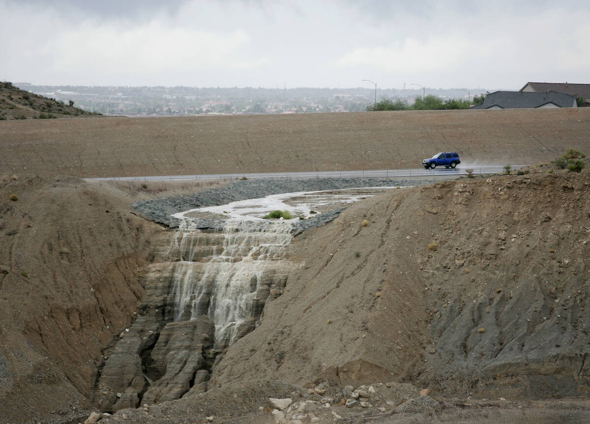 Flooding from an afternoon thunderstorm creates a waterfall into a construction area just west ...