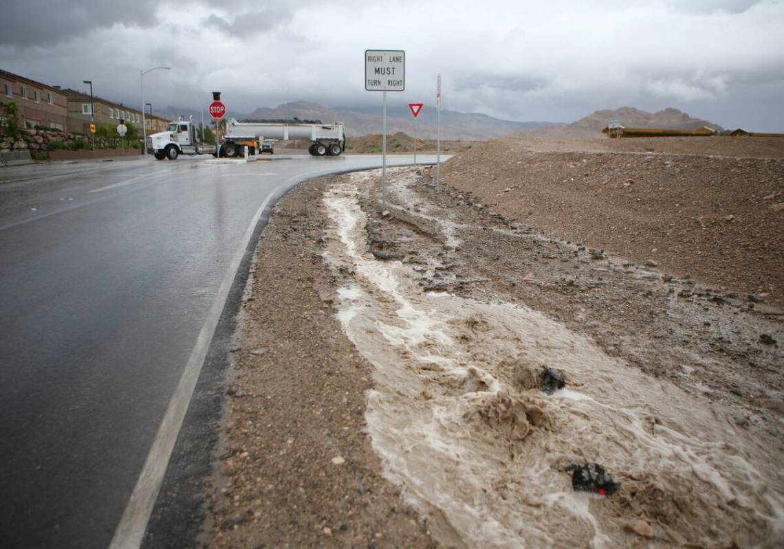 Rainwater floods the ground near Lone Mountain Road west of the 215 Beltway during an afternoon ...