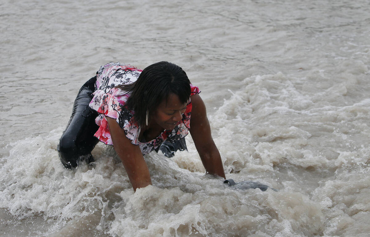Eleanor Brown falls while crossing a flooded street in Las Vegas on Sept. 11, 2012. (John Loche ...