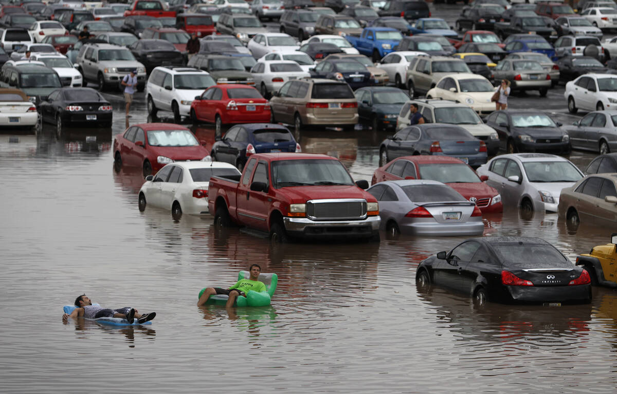 UNLV students Ryan Klorman, left, and Markus Adam float on pool toys in the parking lot of the ...
