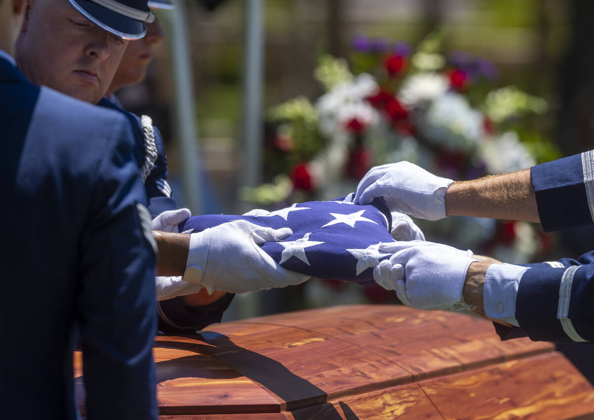 The Nellis Air Force Base Honor Guard folds a flag atop the coffin of Southern Nevada WW II vet ...