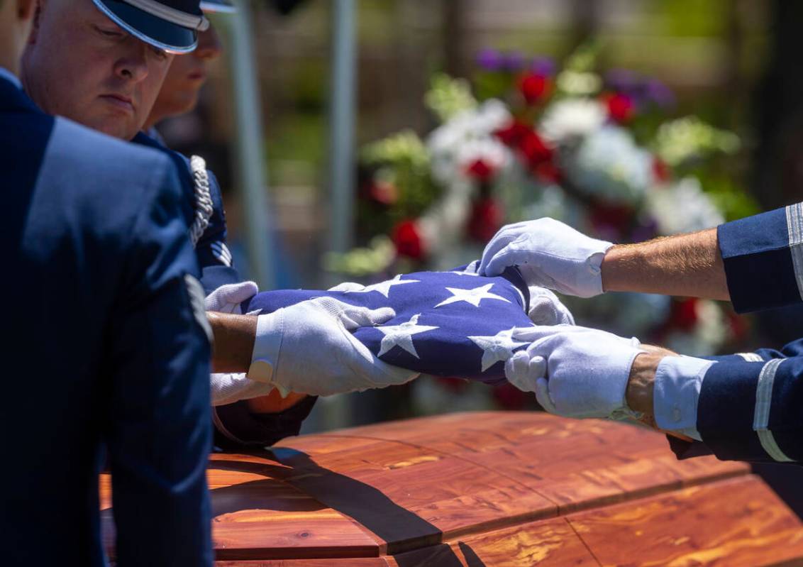 The Nellis Air Force Base Honor Guard folds a flag atop the coffin of Southern Nevada WW II vet ...