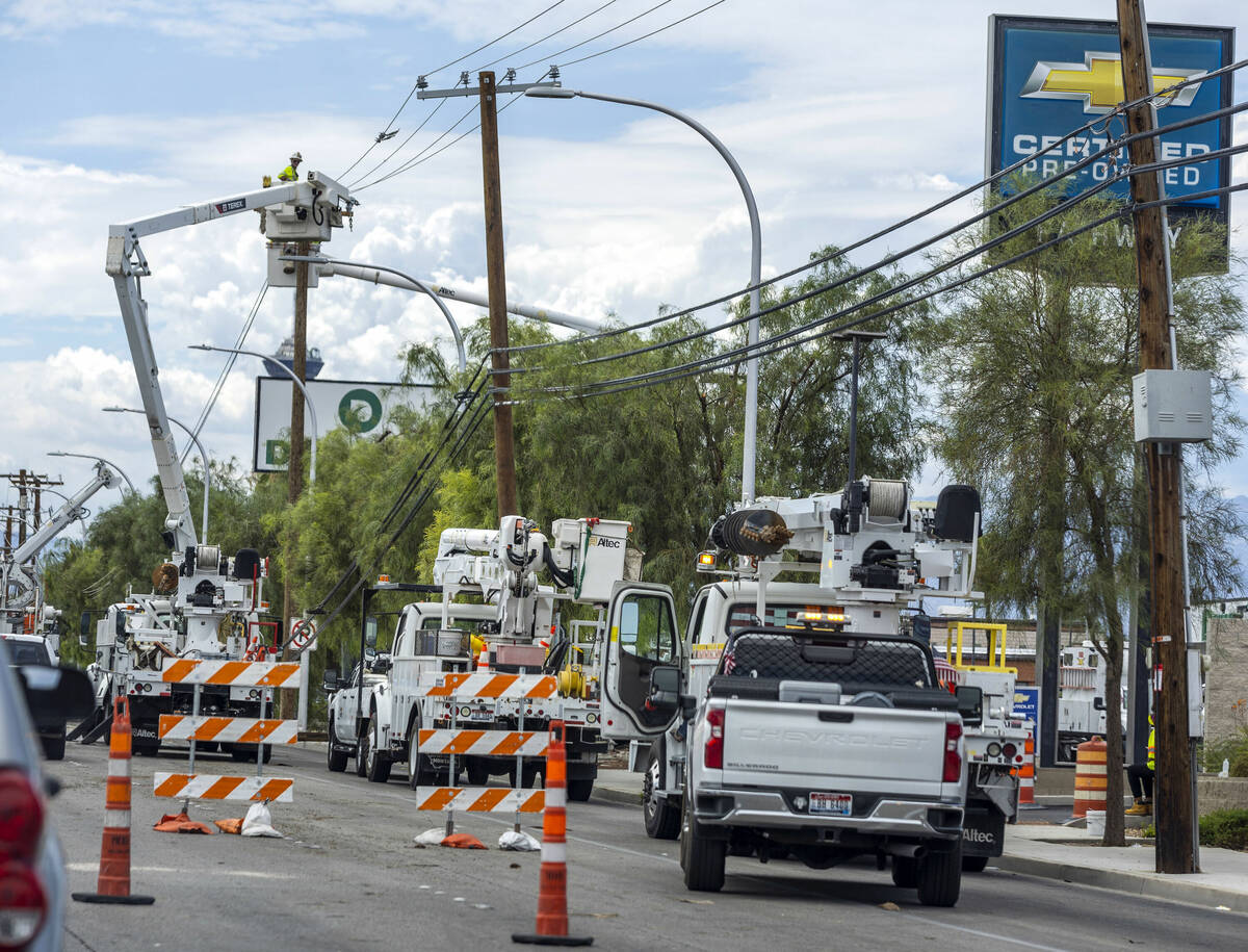 Crews work to hang lines and restore power along the 3000 block of East Sahara Avenue on Saturd ...
