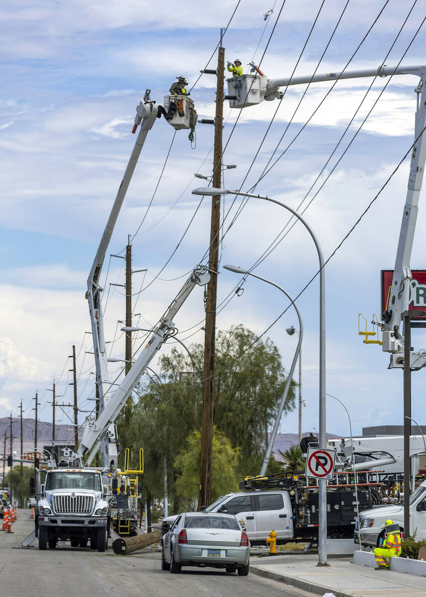 Crews work to hang lines and restore power along the 2900 block of East Sahara Avenue on Saturd ...