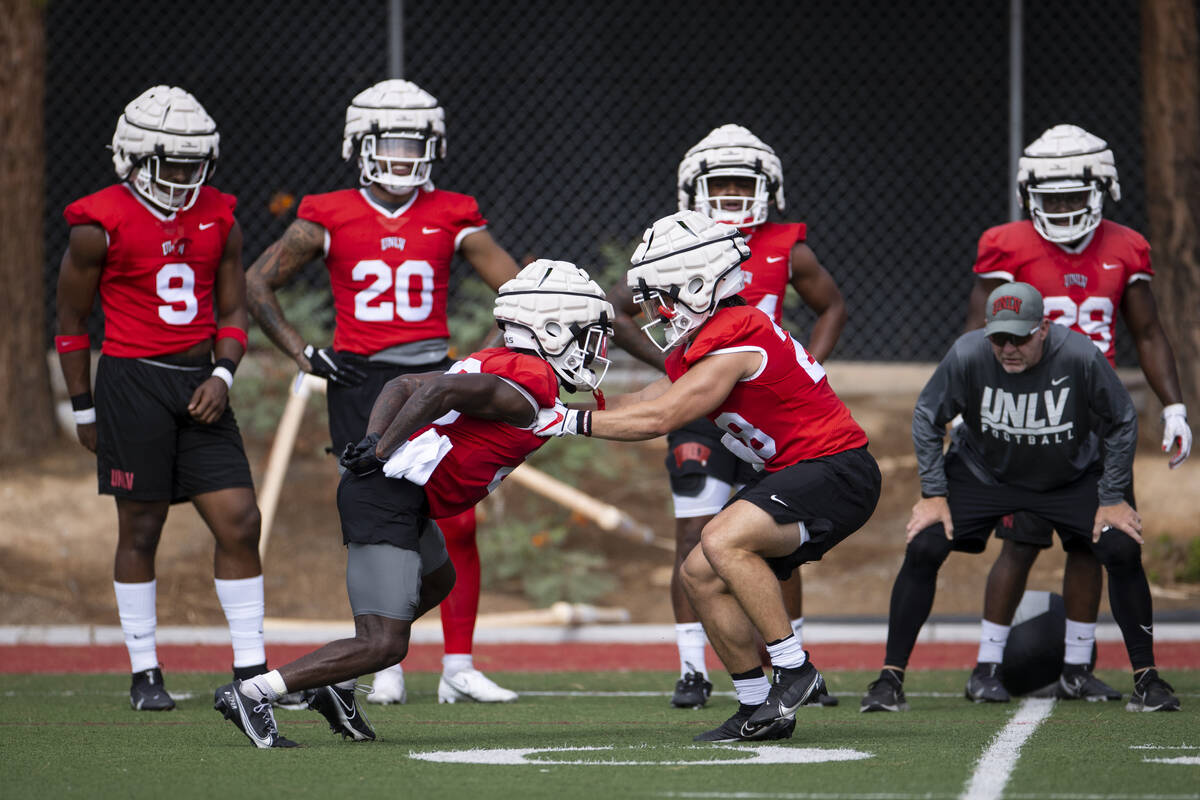 UNLV's Cortney Reese (26), left, and Andrew Wimmer (28), run a drill during a team football pra ...