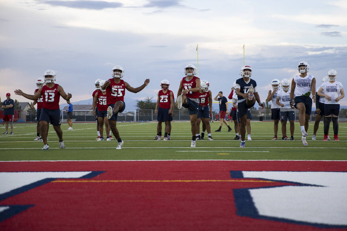 Players warm up during a team football practice at Liberty High School in Henderson, Monday, Au ...