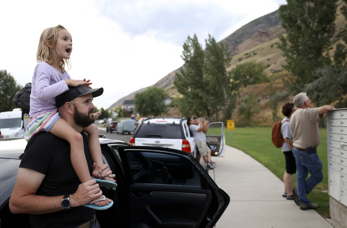 Quinn Smith and her father, David Smith, watch a helicopter take off as firefighters battle a w ...