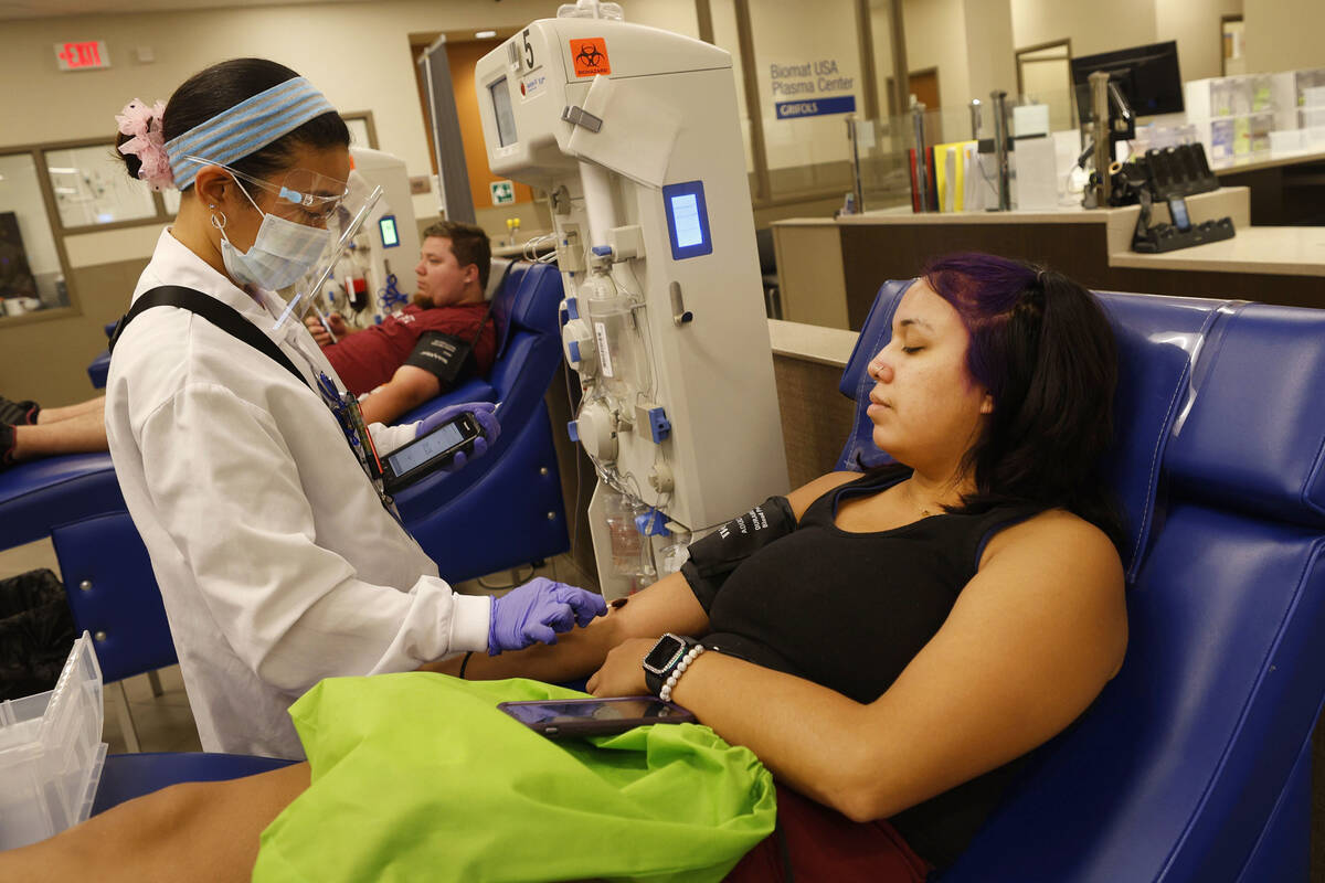 Tracy Hernandez of Las Vegas, right, donates her plasma at the Grifols Biomat USA Plasma Center ...