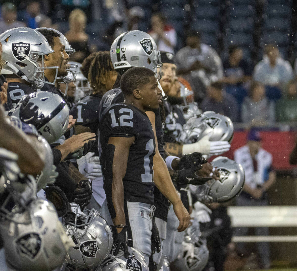 Rain falls as the Raiders wide receiver Justin Hall (12) looks on as Hall of Fame inductees are ...