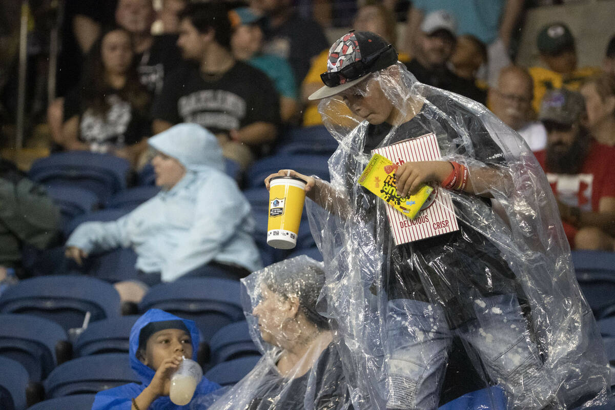 A young fan comes back from the concession stand after a weather delay took effect before the s ...