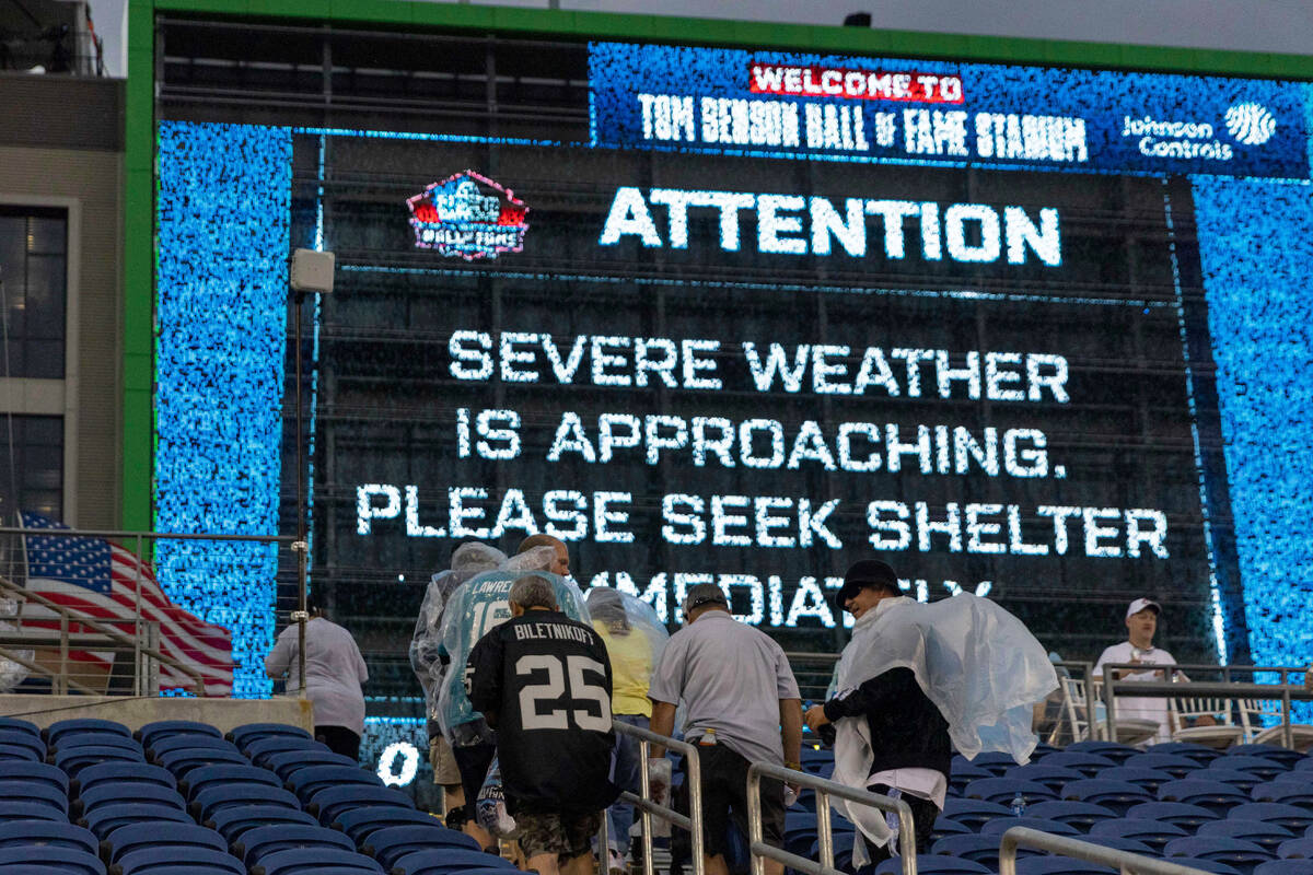 Fans leave their seats to seek shelter during a weather alert that delayed the start of the NFL ...