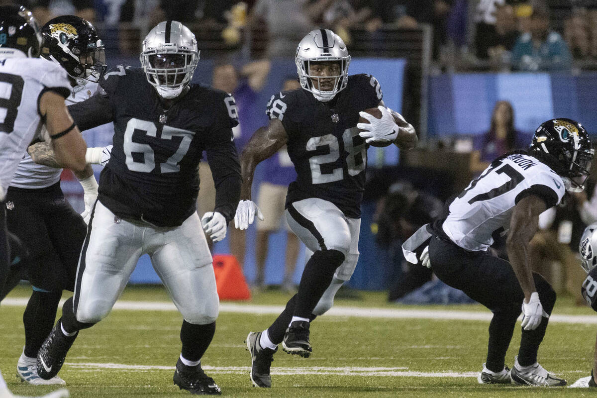Raiders guard Lester Cotton Sr. (67) blocks as Raiders running back Josh Jacobs (28) finds more ...