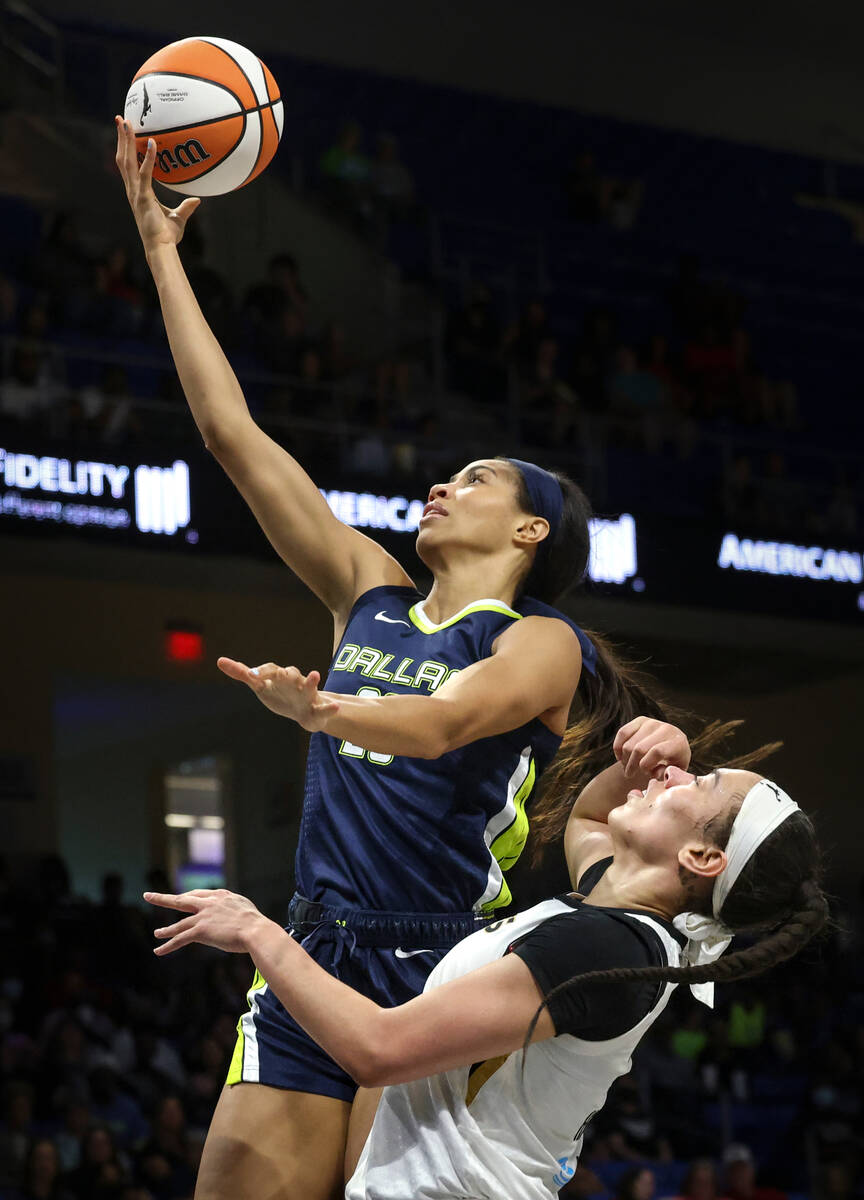 Dallas Wings forward Isabelle Harrison shoots while defended by Las Vegas Aces forward Dearica ...