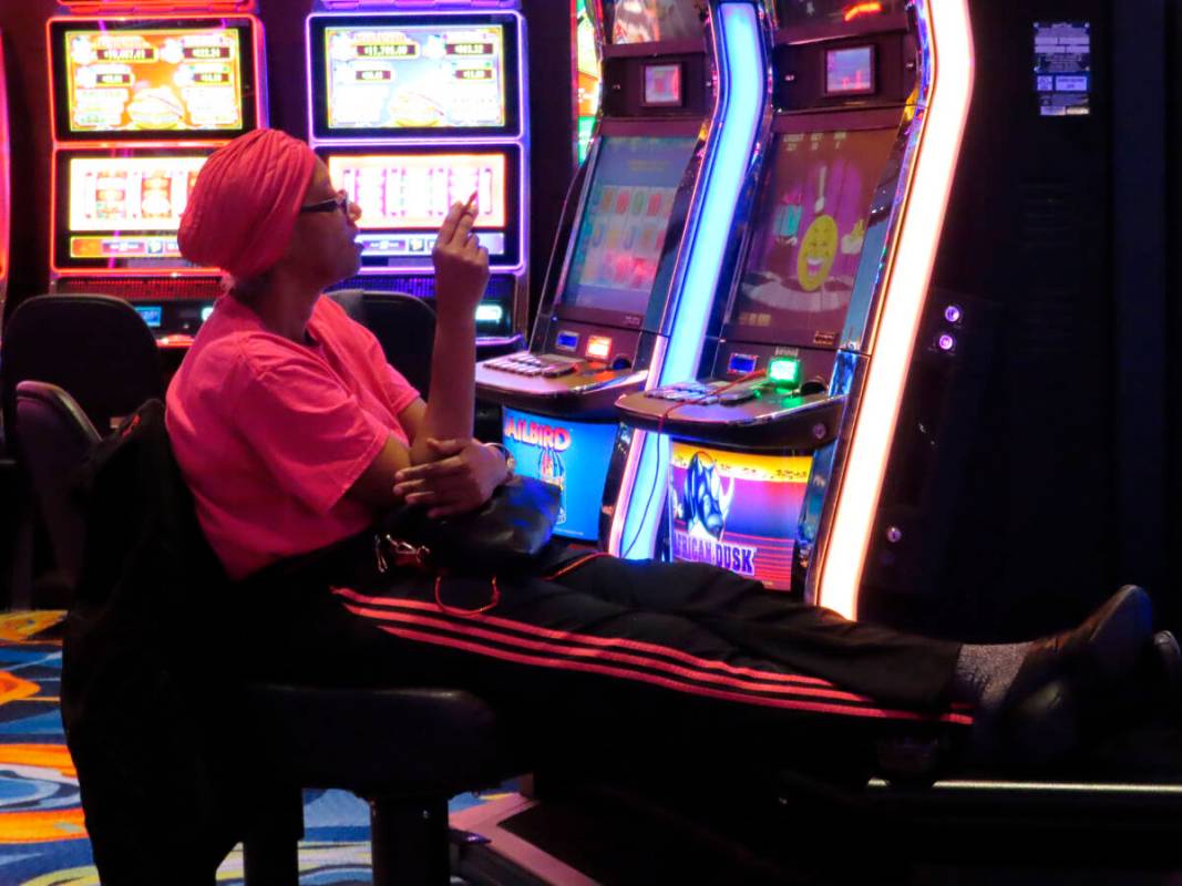 This Feb. 10, 2022, photo shows a gambler smoking while playing a slot machine at the Ocean Cas ...