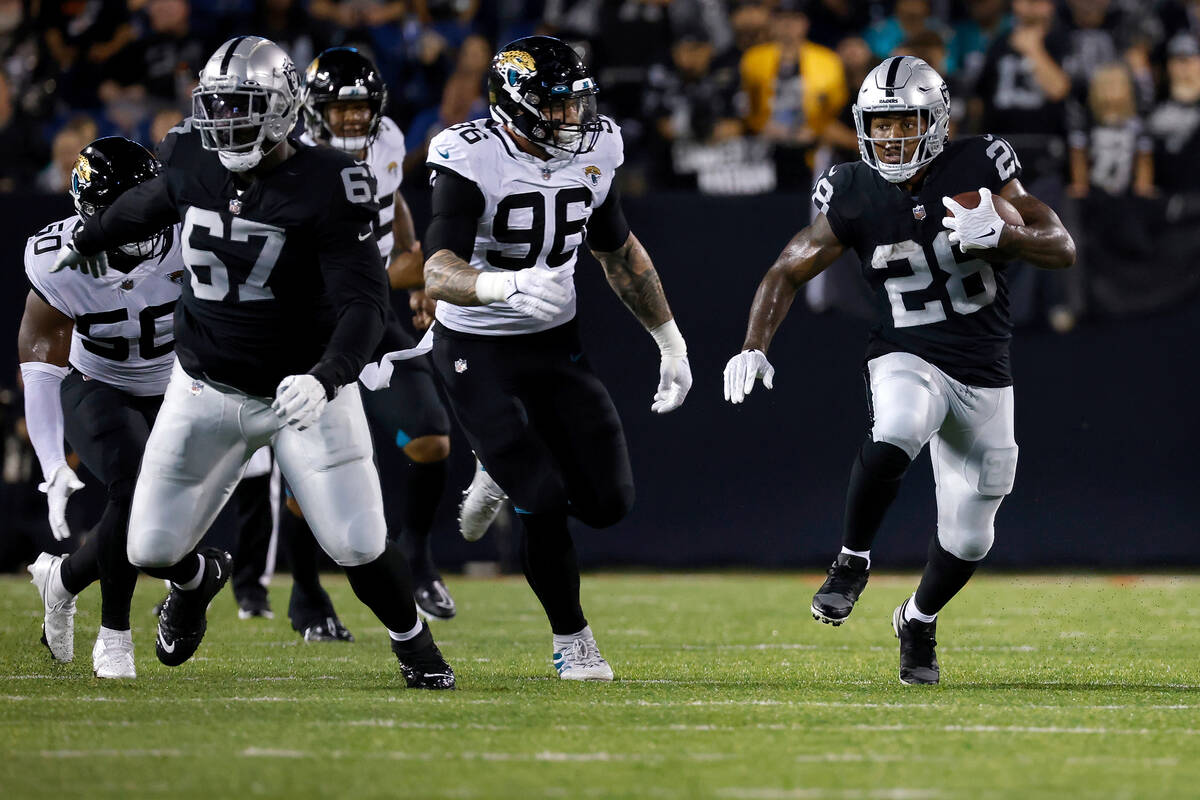 Las Vegas Raiders running back Josh Jacobs (28) runs the ball up the field during an NFL presea ...