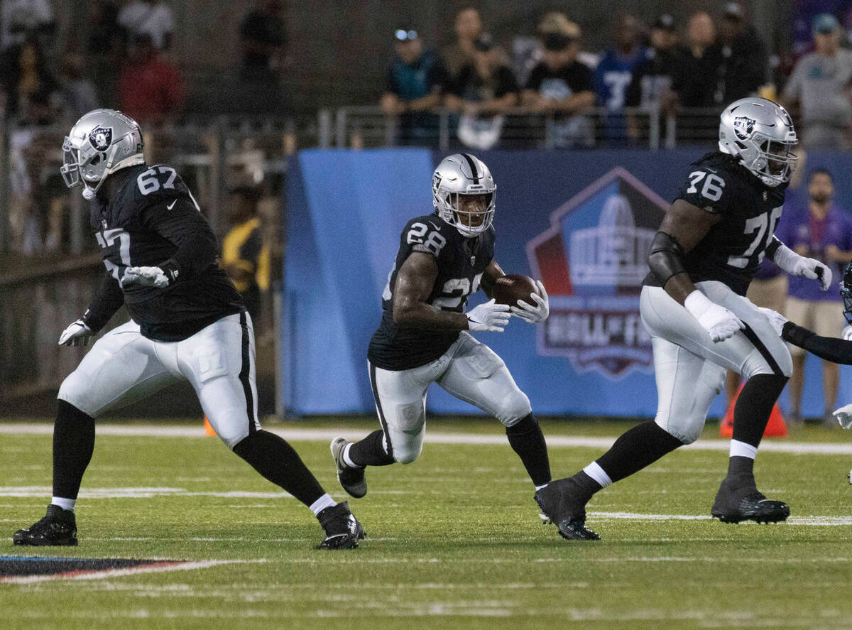Raiders running back Josh Jacobs (28) rushes during the first half of the NFL Hall of Fame game ...
