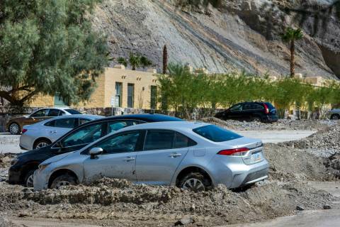Cars remain stuck in mud flows in the parking lot of The Inn at Death Valley at the national pa ...