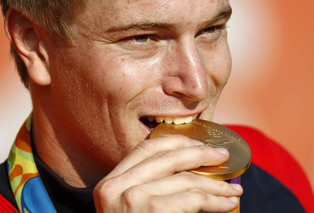 Connor Fields of the United States bites his gold medal for photographers during a victory cere ...