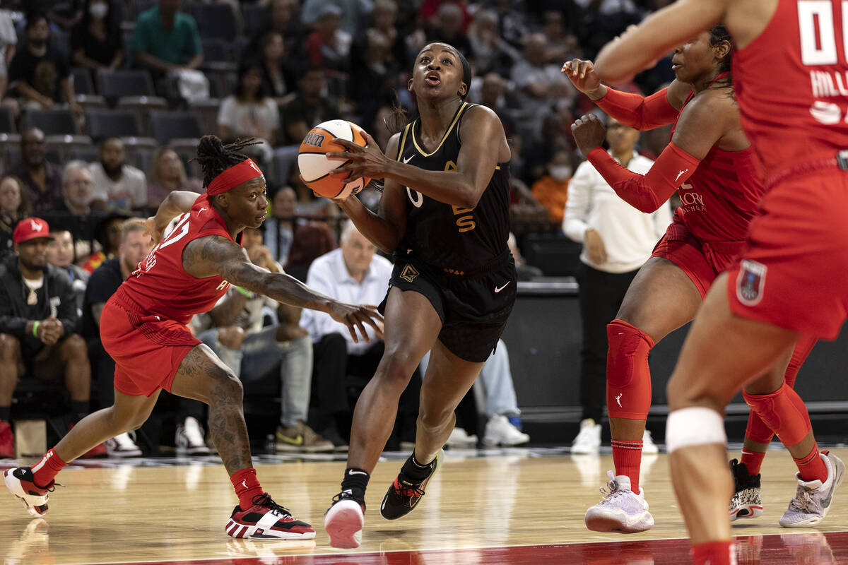 Las Vegas Aces guard Jackie Young (0) drives toward the hoop while Atlanta Dream guard Erica Wh ...