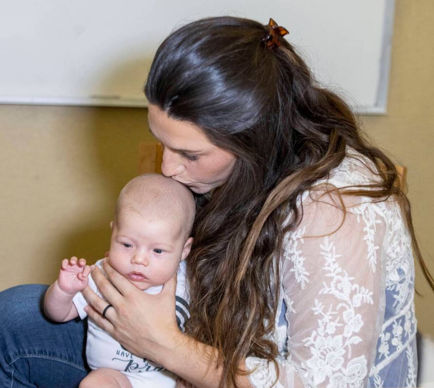 Carly Sieg, wife of Raiders long snapper Trent Sieg, not pictured, kisses their three-month-old ...