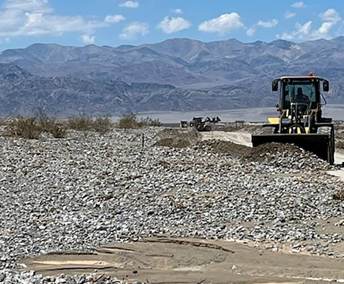 Heavy equipment removes several feet of rocks and flood debris from a road in Death Valley on S ...