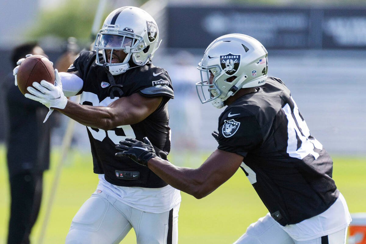 Raiders cornerback Nate Hobbs (39) holds onto the football as cornerback Sam Webb (48) tries to ...