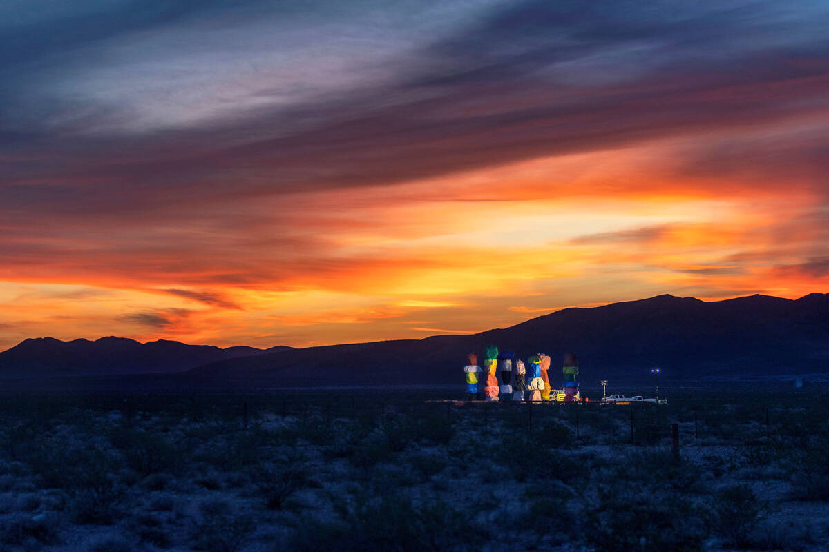 Work lights illuminate the Seven Magic Mountains at sunrise as the art installation undergoes r ...