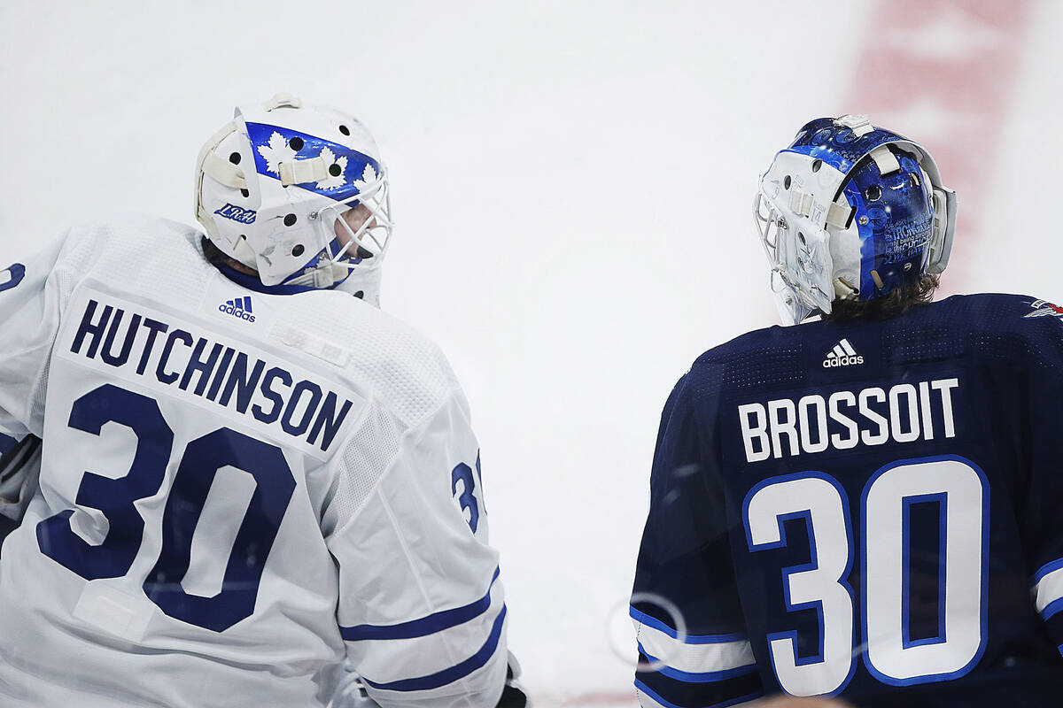 Winnipeg Jets goaltender Laurent Brossoit, right, and Toronto Maple Leafs goaltender Michael Hu ...