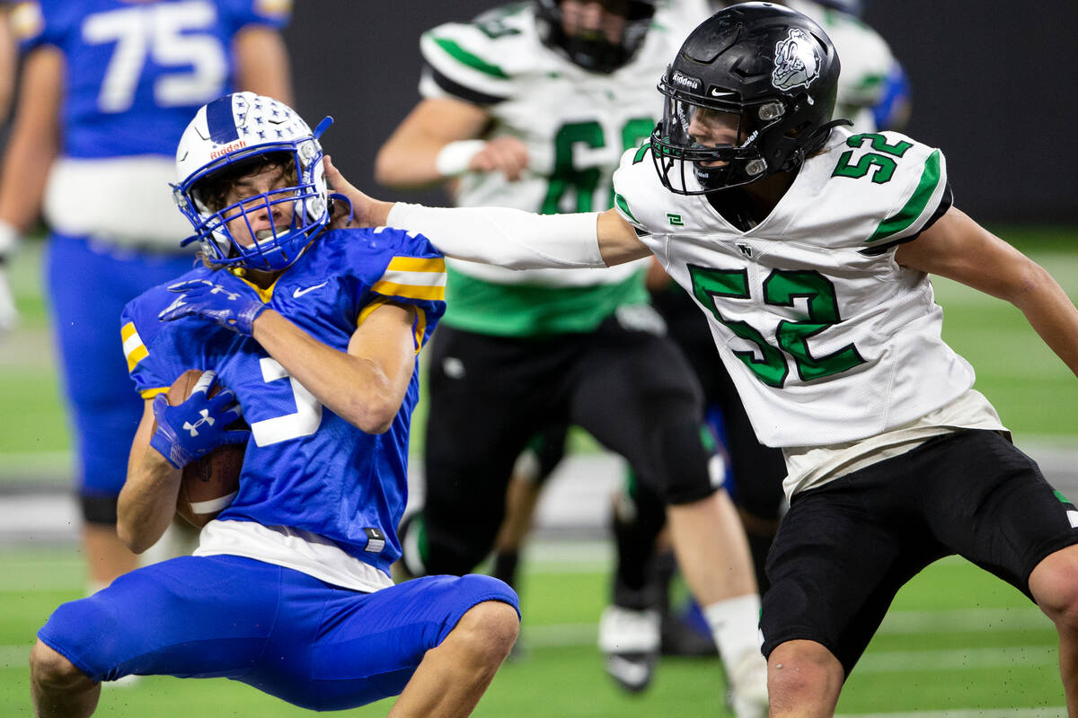 Moapa Valley wide receiver Dustin Gordon (3) is brought down in part by Virgin Valley linebacke ...