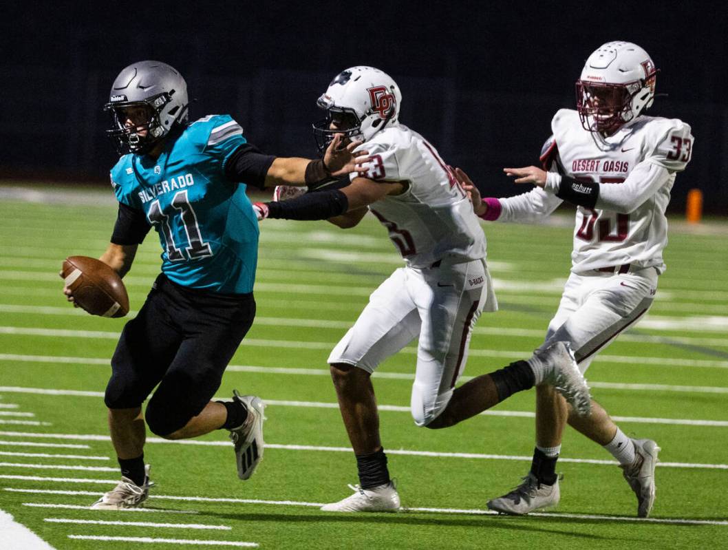 Siverado HighÕs quarterback Brandon Tunnell (11) pushed out of bound by Desert Oasis High& ...