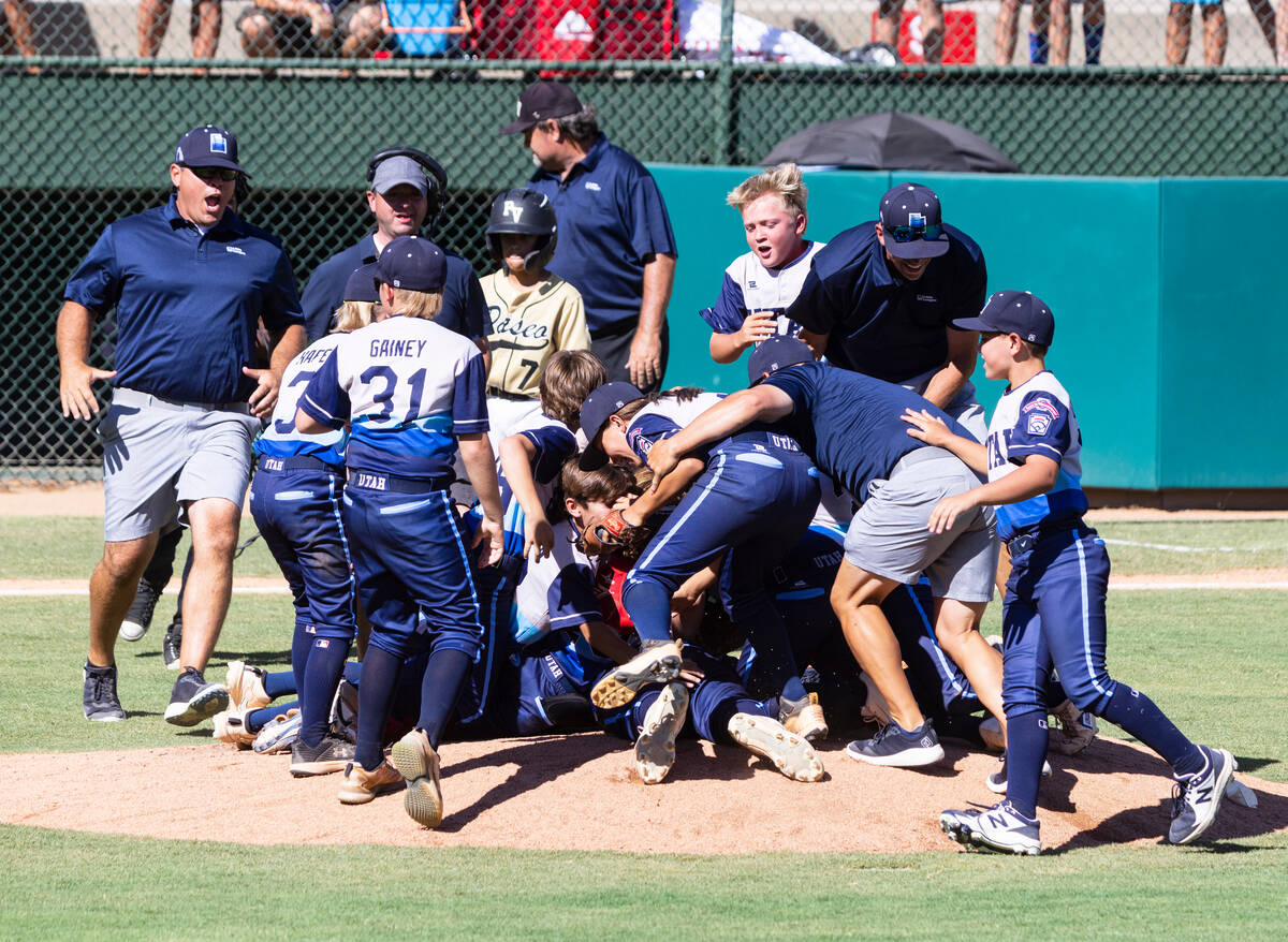 Paseo Veda's head coach Bill Senne, center, and third baseman Mason Zoller (7) walk past Utah-S ...