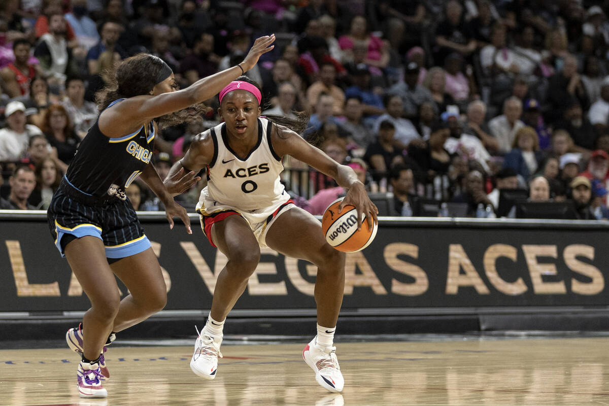 Las Vegas Aces guard Jackie Young (0) dribbles around Chicago Sky guard Dana Evans (11) during ...