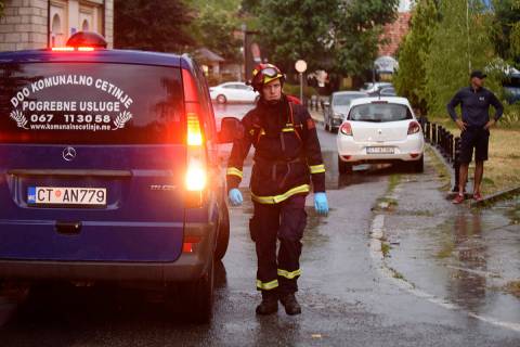 A firefighter walks by a hearse on the site of the attack in Cetinje, 36 kilometers (22 miles) ...
