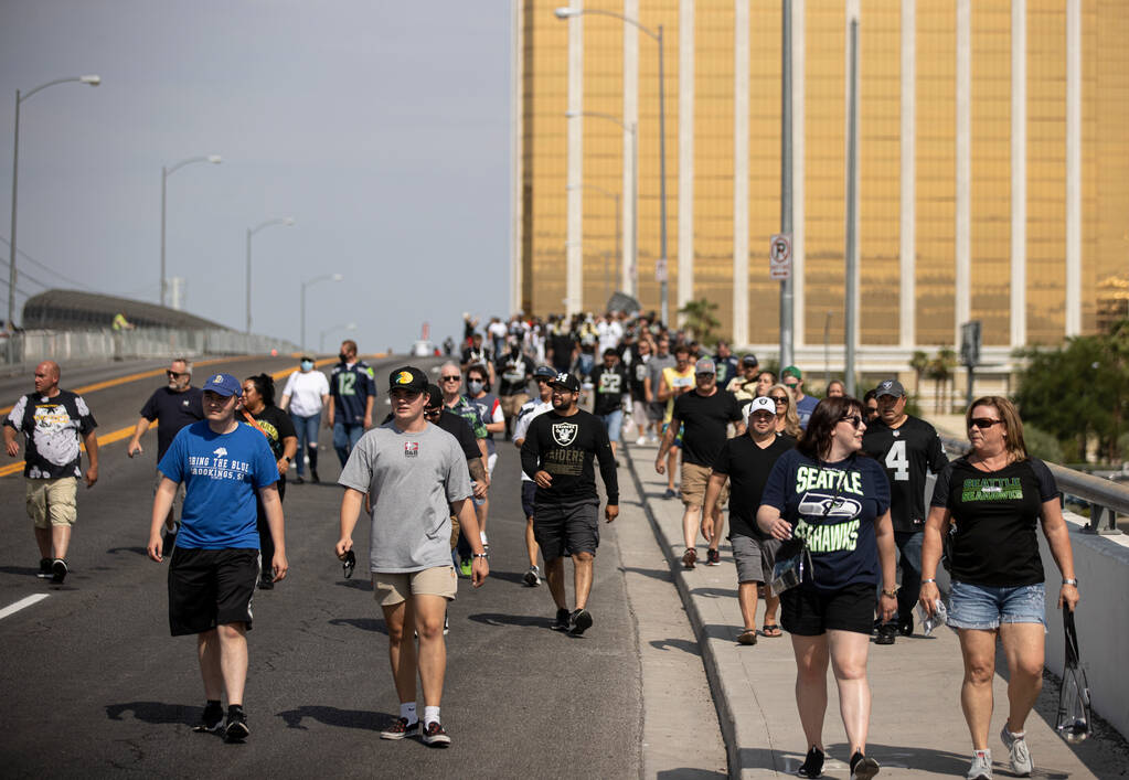 Raiders fans make their way to Allegiant Stadium before the start of an NFL preseason football ...
