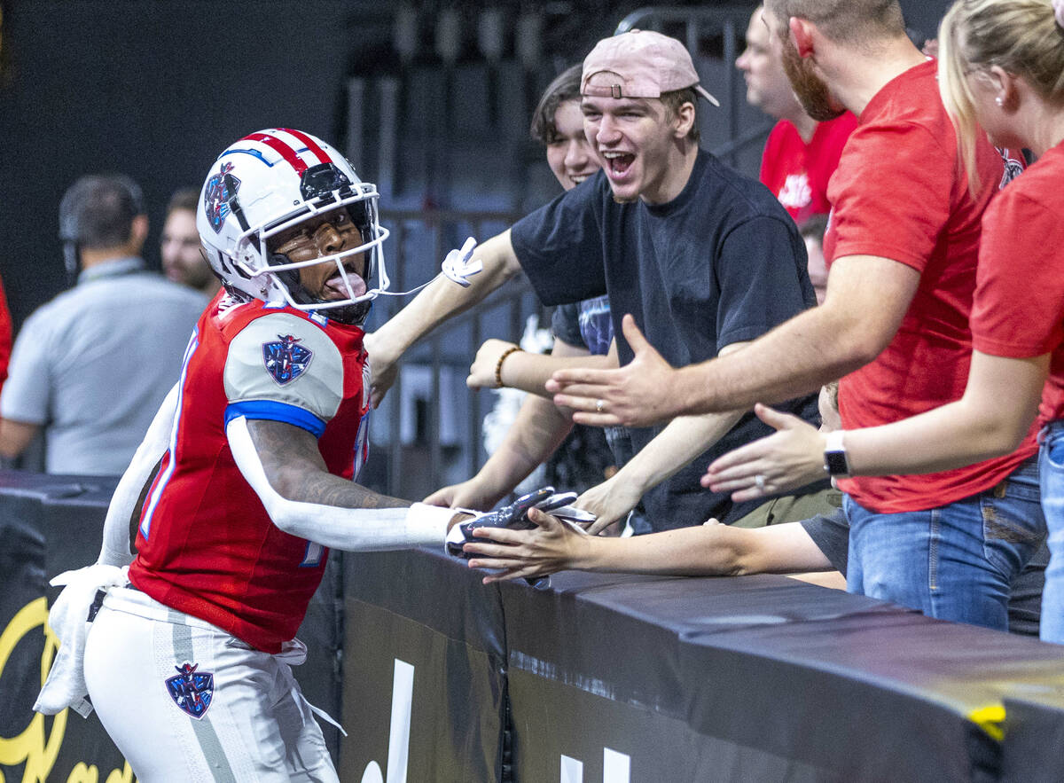 Northern Arizona Wranglers running back Bill Atkins (11) celebrates a score with fans over the ...