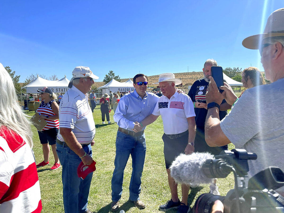 Republican Nevada Senate candidate Adam Laxalt, center left, takes pictures with supporters at ...