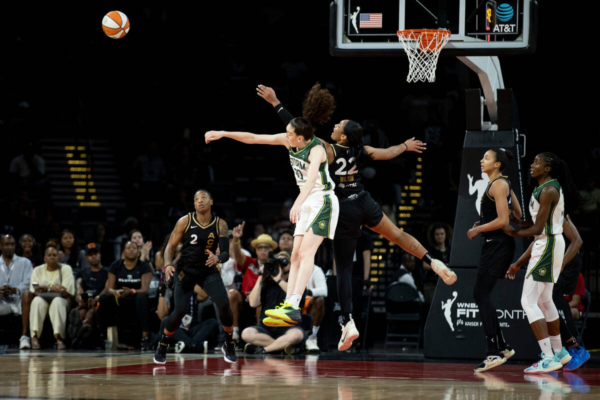 Aces forward A'ja Wilson (22) and Storm forward Breanna Stewart (30) fight for a rebound as the ...