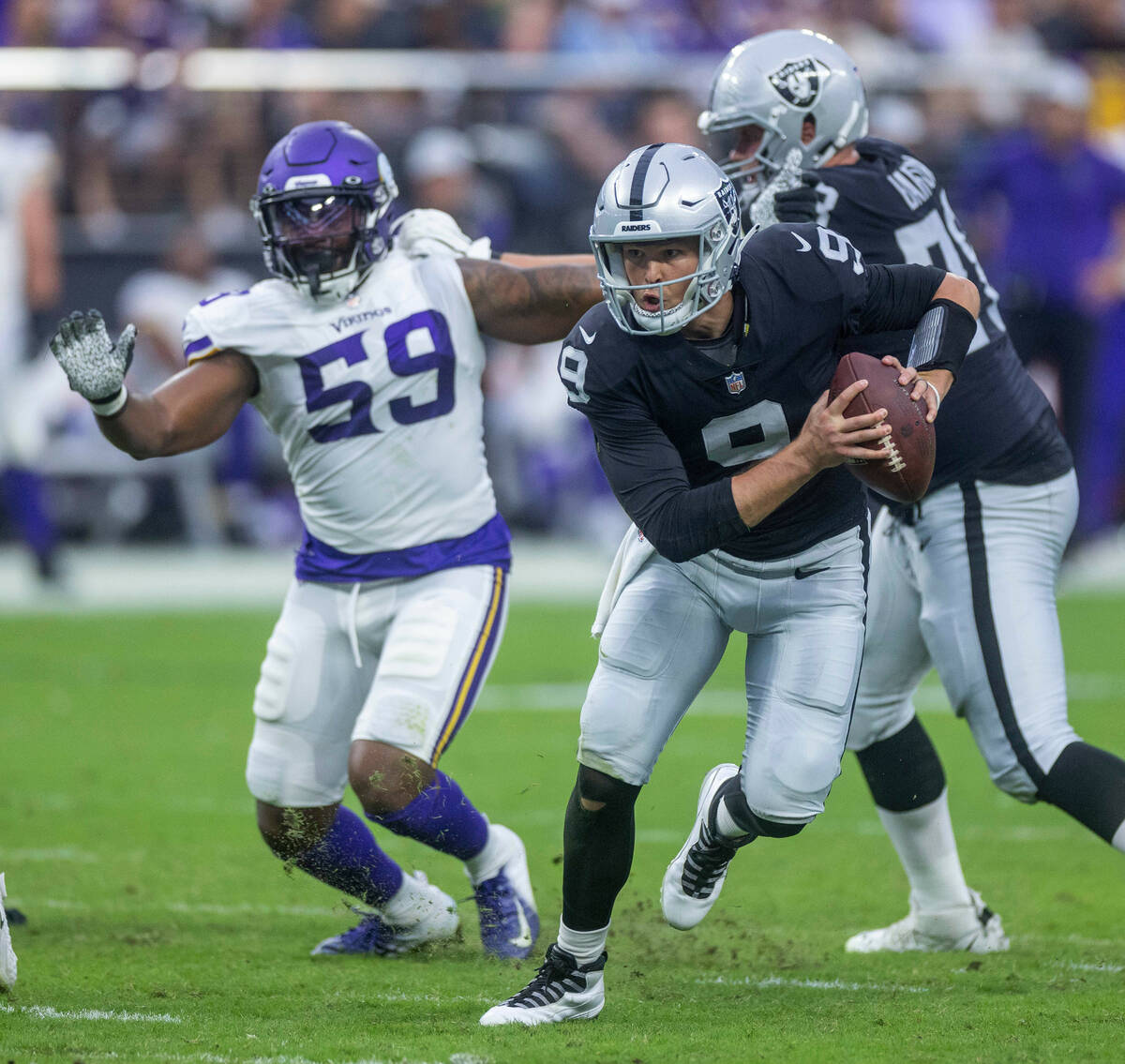 Raiders quarterback Nick Mullens (9) scrambles for extra yards on a run as Vikings linebacker Z ...