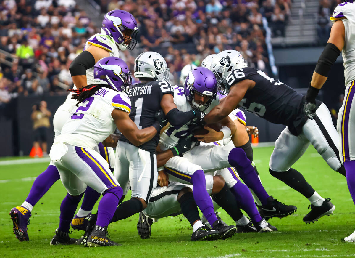 Minnesota Vikings quarterback Sean Mannion (14) gets sacked by the Raiders during the first hal ...