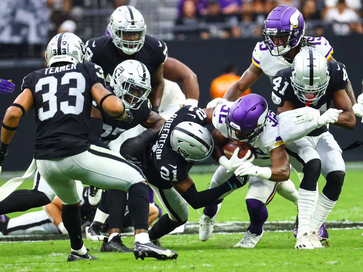 Minnesota Vikings running back Ty Chandler (32) gets tackled by Raiders cornerback Amik Roberts ...