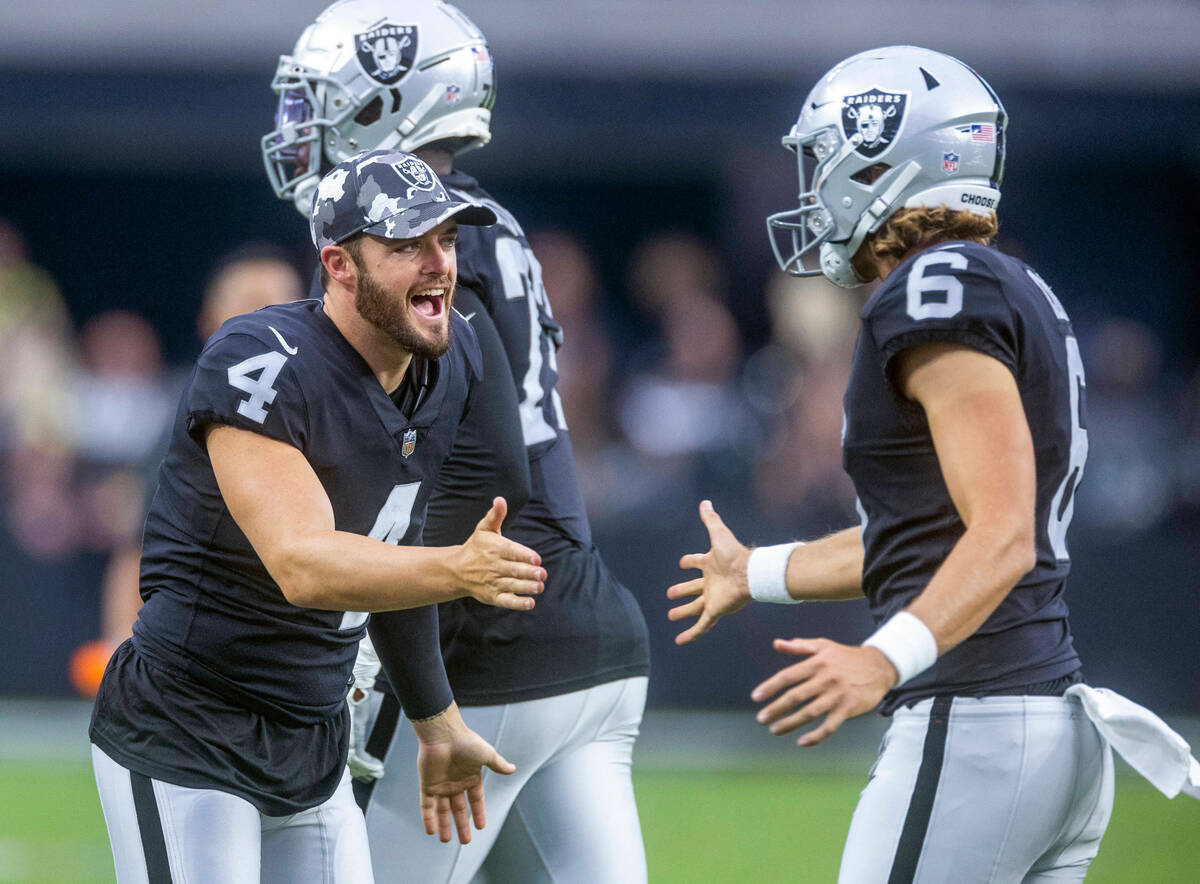 Raiders quarterback Derek Carr (4) congratulates punter AJ Cole (6) on a successful kick hold a ...