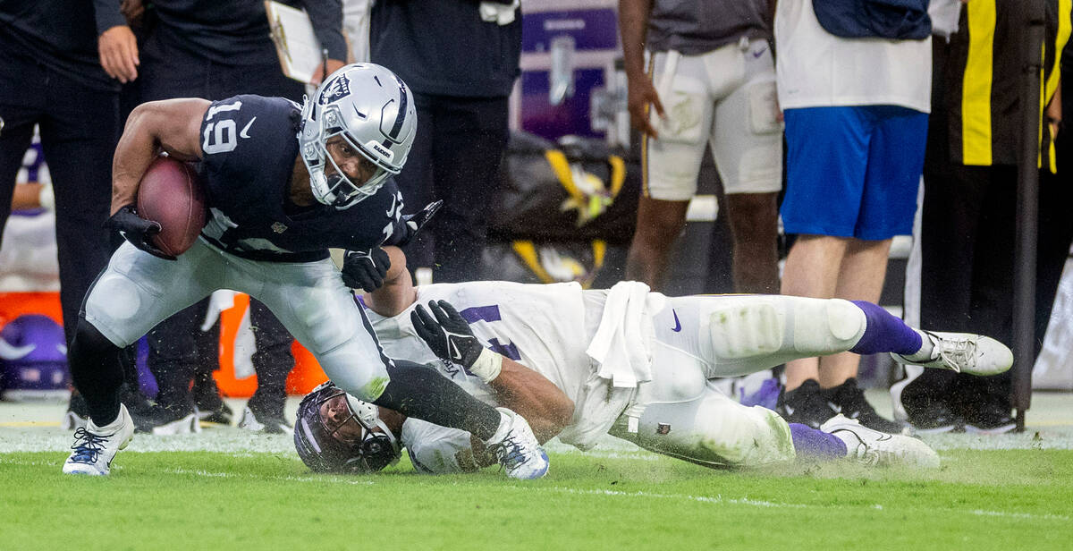 Raiders wide receiver DJ Turner (19) avoids a diving tackle by Vikings linebacker Chazz Surratt ...