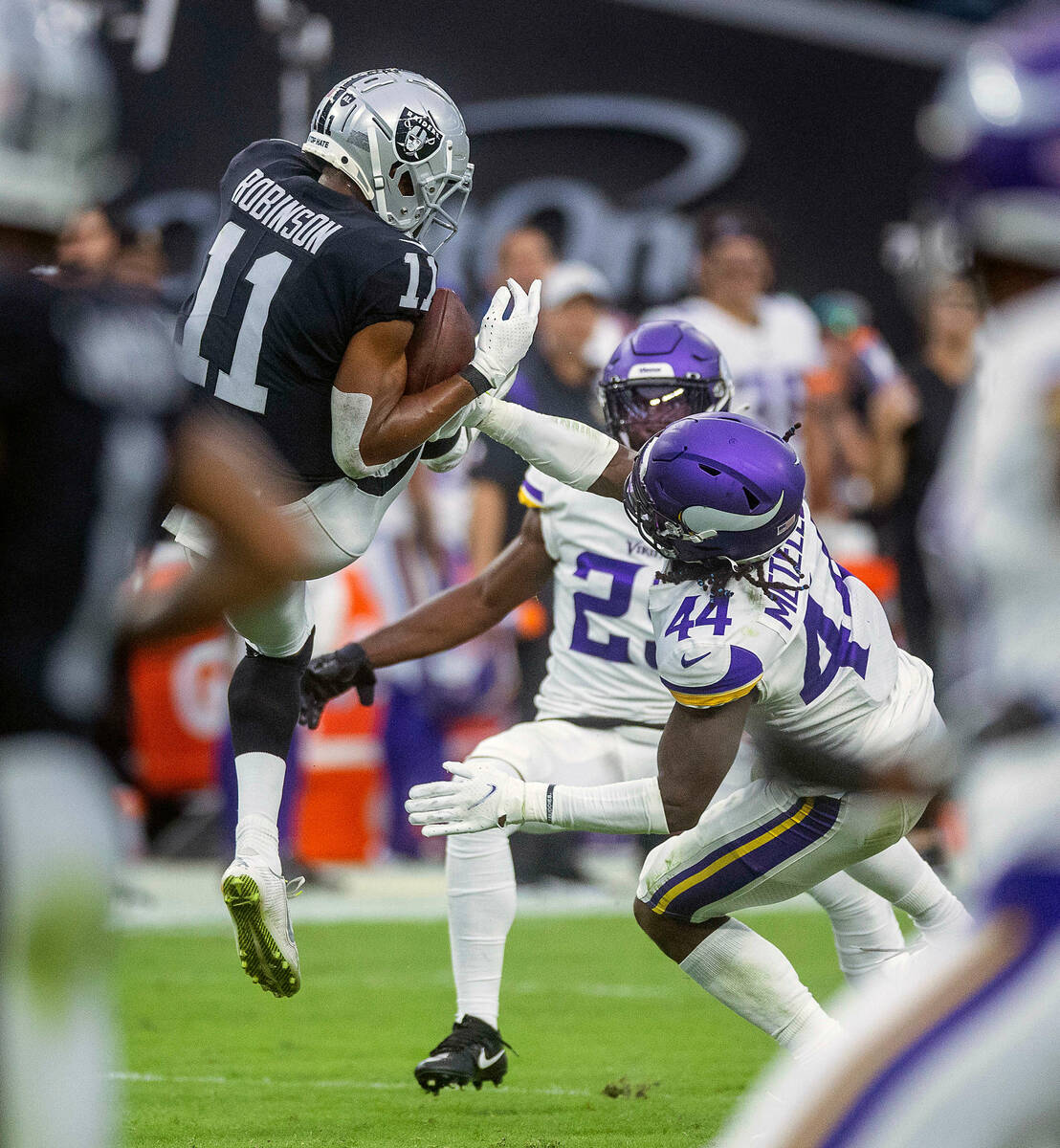 Raiders wide receiver Demarcus Robinson (11) elevates for a catch over Vikings safety Josh Mete ...