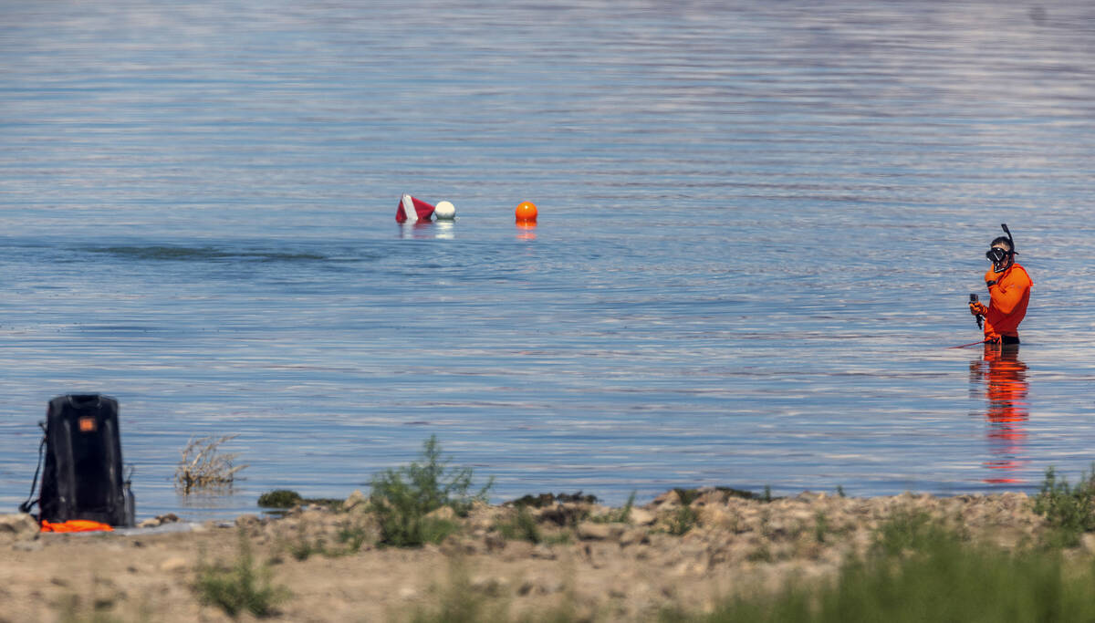 A search and rescue diver works the shallows as authorities are assessing what were described a ...