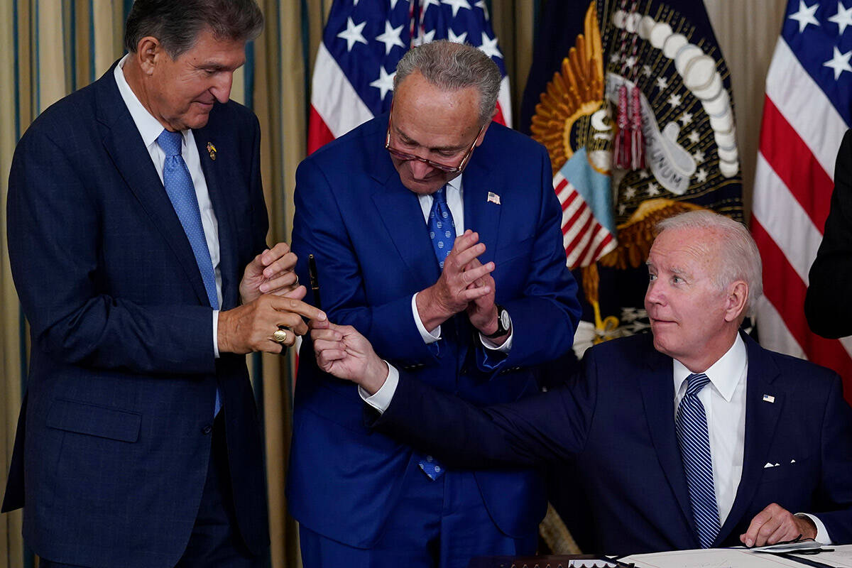 President Joe Biden hands the pen he used to sign the Democrats' landmark climate change and he ...