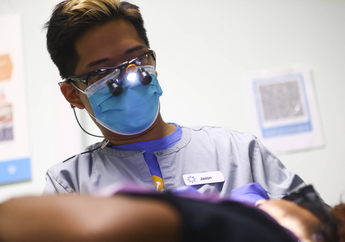 Dental assistant Jason Saavedra works with patient and recent Clark High School graduate Josely ...